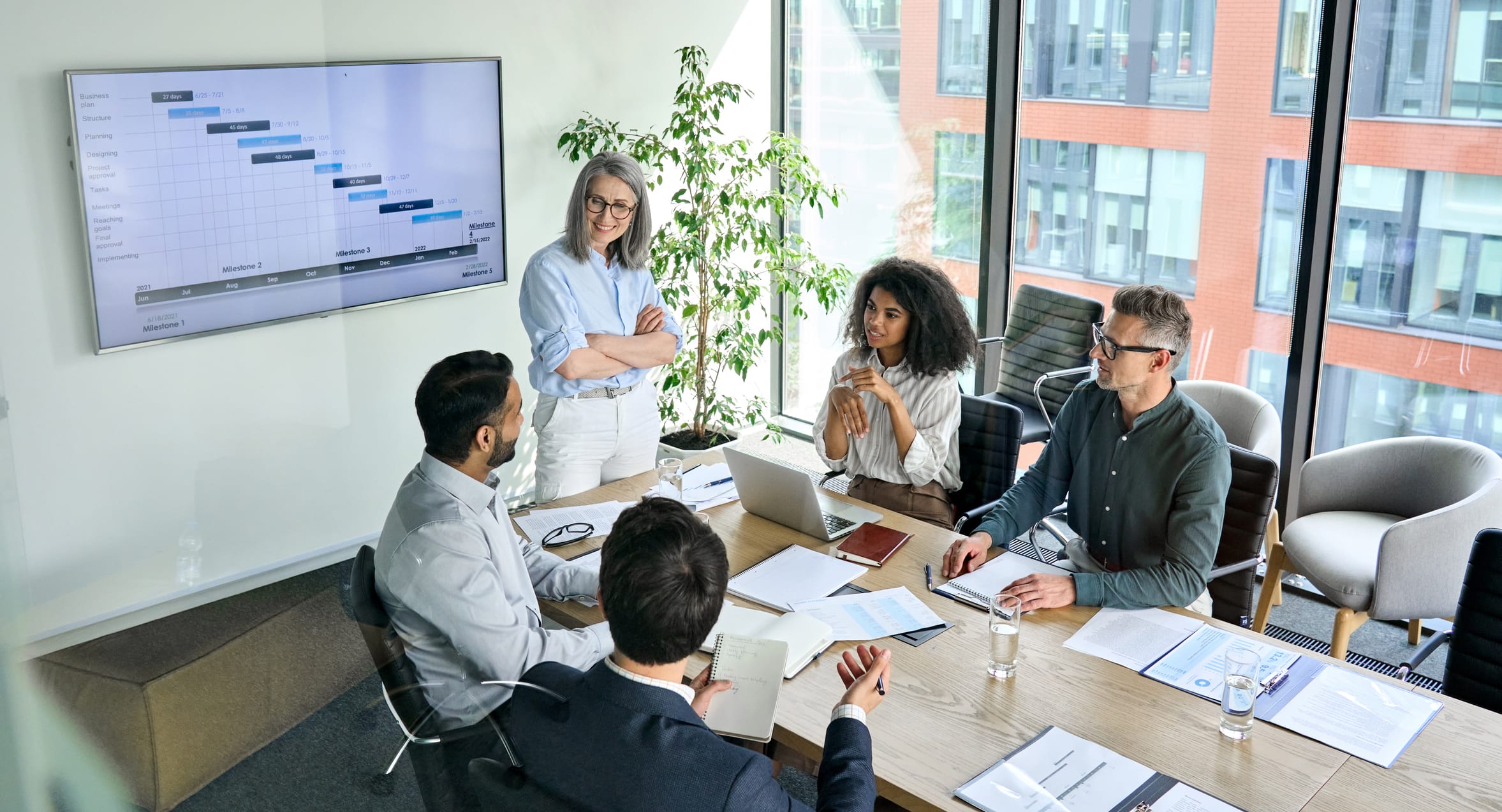 Diverse corporate team working together in modern meeting room office. Innovation Partners meeting room